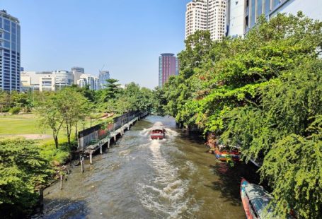 Cultural Origins - a boat traveling down a river next to tall buildings