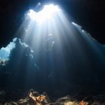 Discovering Nature - a sunbeam shines through a cave in the ocean